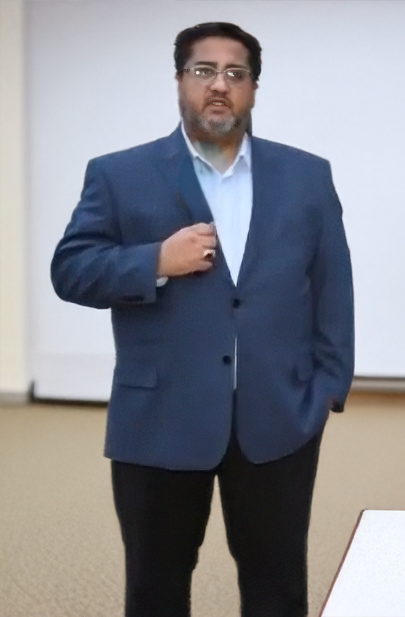 Ali Hassanali — CEO of Al-Ayn Social Care Foundation, wearing a navy blue blazer and light blue shirt
